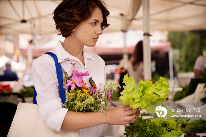 Woman buying vegetables at market