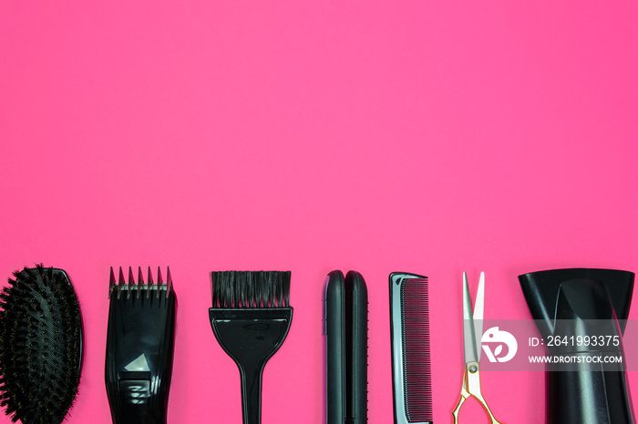 Hairdresser set with various accessories on a pink background with copy space