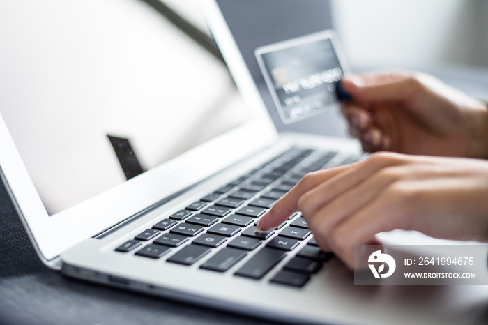 Woman holding credit card and using computer for online shopping