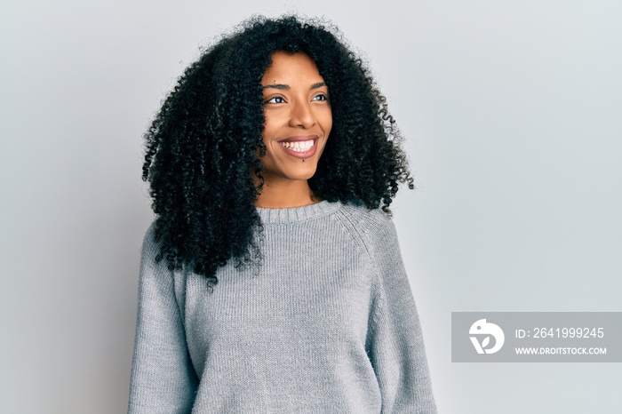 African american woman with afro hair wearing casual winter sweater looking to side, relax profile p