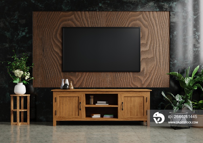 TV on the wooden wall in the living room Decorated with wooden cabinets and plants on tiled floors. 