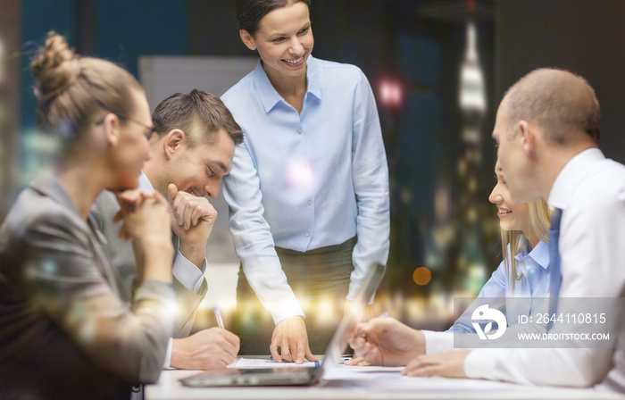 smiling female boss talking to business team