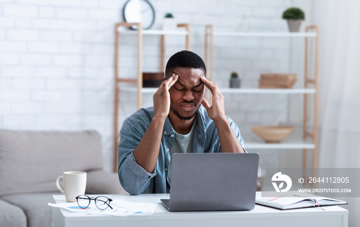 African American Businessman Having Headache Sitting At Laptop Indoor