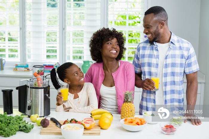 Parents and daughter having a glass of fruit juice