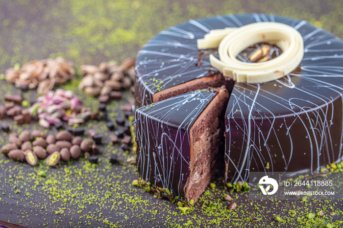 Pistachio cake sliced on white wooden background. Homemade Chocolate Cake with Dark Chocolate Glaze 