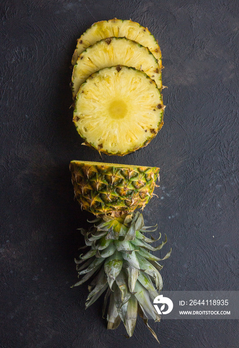 Pineapple on wood texture background. Whole and sliced tropical pineapple on wooden cutting board wi