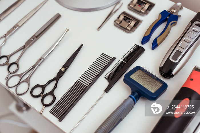 close-up view of set of various groomer tools on white table in pet salon