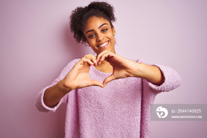 Young african american woman wearing winter sweater standing over isolated pink background smiling i