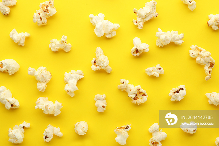 Tasty scattered popcorn on color background