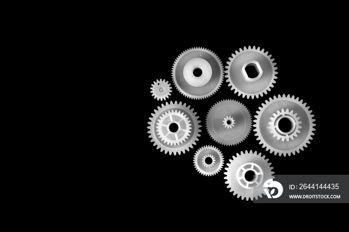 White plastic gears isolated on black background.