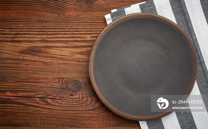木桌上的餐巾和深色盘子