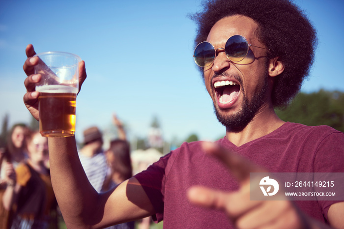 Screaming African man drinking beer at the music festival