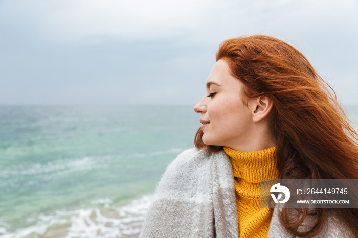 Beautiful young redheaded woman wearing coat