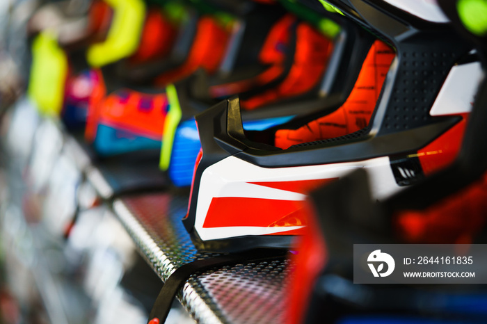 A row of motorcycle helmets on the shelf in the store