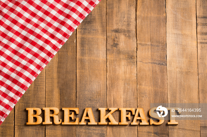 Picnic breakfast - Checkered red napkin and wooden letters. Background for design. Top view