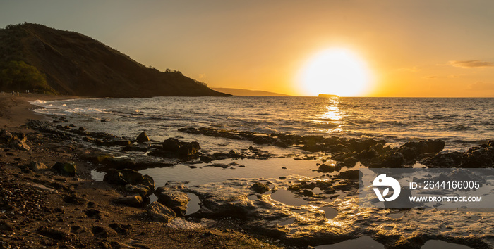日落在美国夏威夷毛伊岛马克纳州立公园奥涅利海滩裸露的熔岩礁上