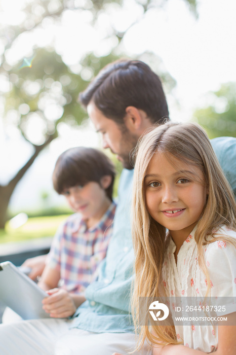 Portrait smiling girl with father and brother