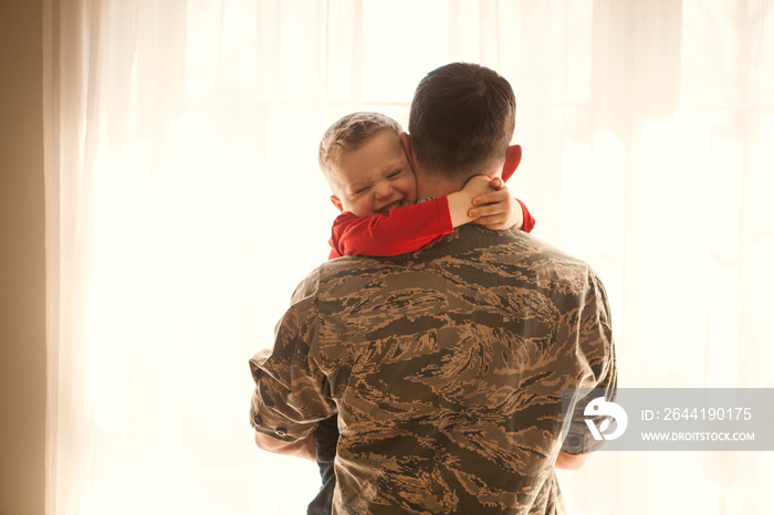 Boy embracing his father at home