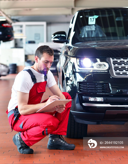 汽车修理厂-工人检查和调整汽车照明系统的前灯