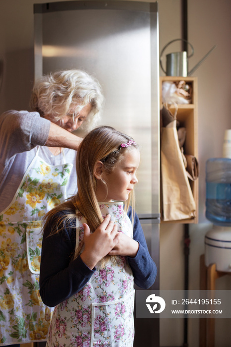 Grandmother with her granddaughter wearing aprons