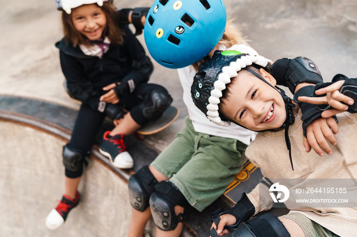 Happy cheerful kids with skateboards at the ramp