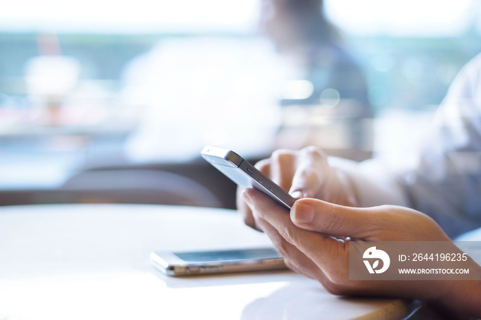 Businessman using mobile payments in office background