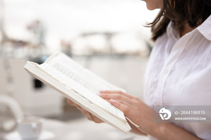 Female hands holding a book close up.