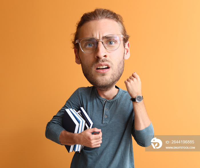 Stressed male student with big head on color background