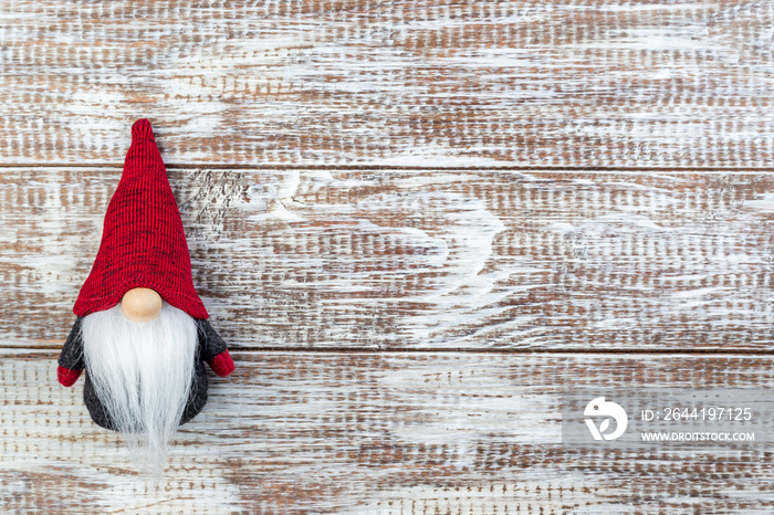 Gnome or swedish tomte soft toy, on wooden background, horizontal, copy space, top view