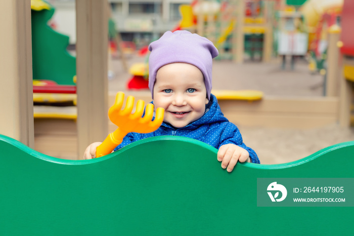 Cute adorable caucasian toddler boy enjoy having fun at outdoor playground. Portrait of happy little