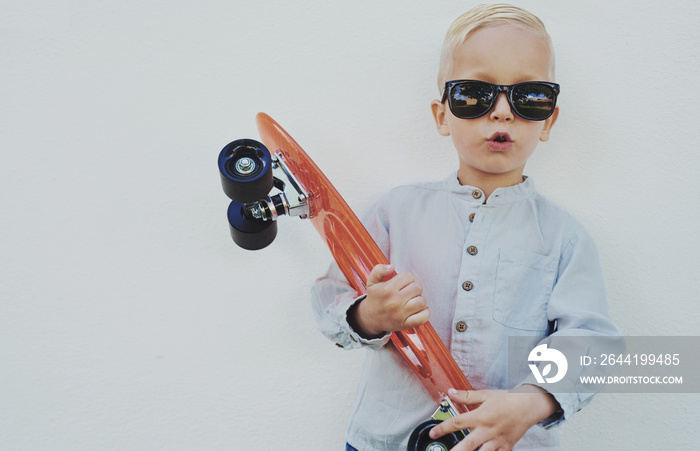 Cute hipster little boy with a skateboard