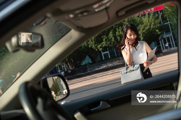 打电话的青年女人走向汽车