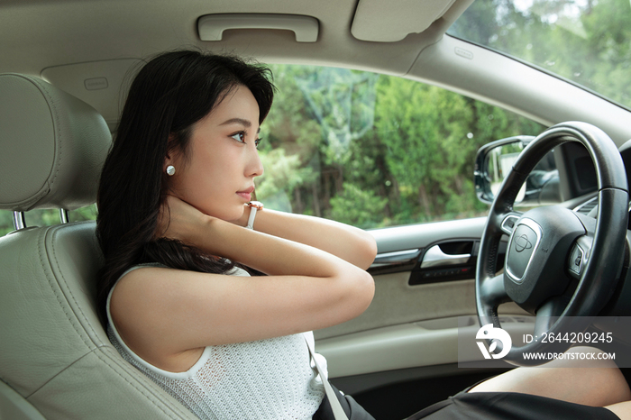 驾驶座上的青年女人按摩颈椎