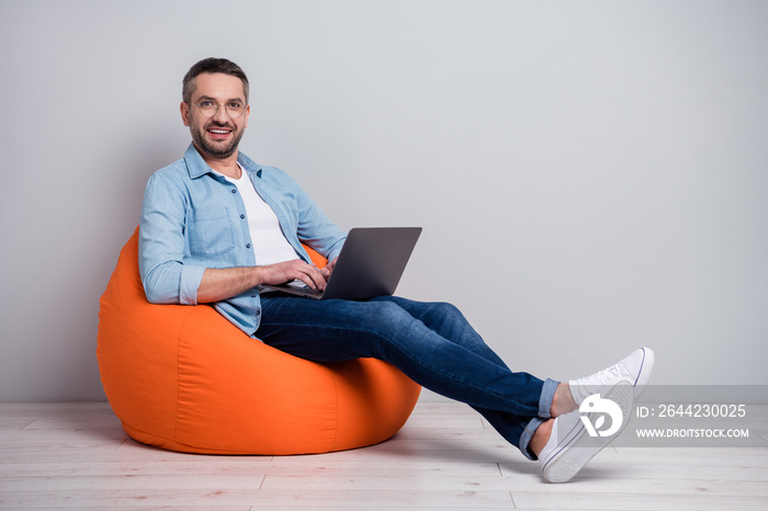 Portrait of his he nice attractive cheerful cheery content gray-haired guy using laptop developing c