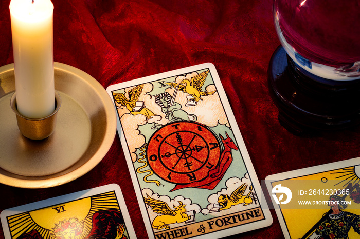 Wheel of fortune card and crystal ball under candle light. Cartomancy is fortune telling using cards