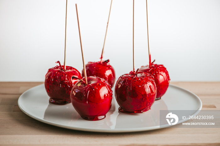 Candied apples on stick on plate.