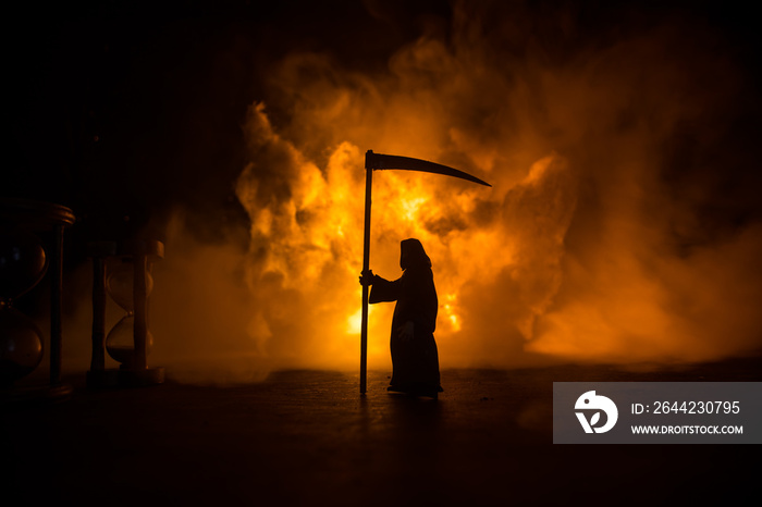 Scary view of grim reaper at cemetery with spooky cloudy sky and fog, Horror Halloween concept. Sele