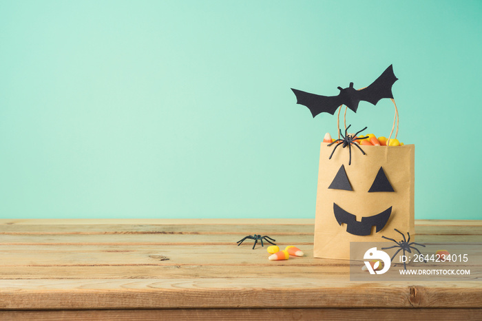 Halloween holiday concept with party gift paper bag decor and candy corn  on wooden table