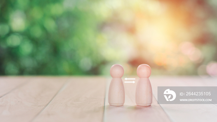 Business to the business concept. Two wooden figure models stand on wooden table with white arrow.