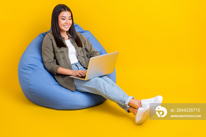 Full length size photo of young student japanese girl sitting beanbag use netbook do remote homework