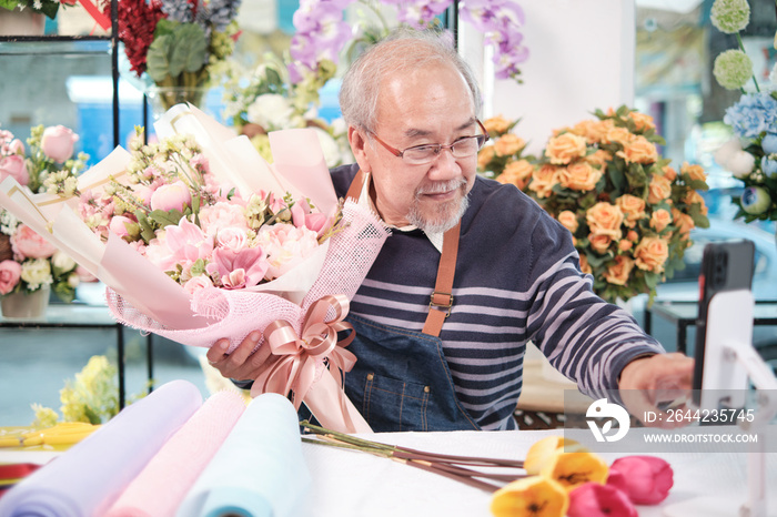 E-commerce business, one senior male florist workers demonstrate and show floral arrangements via on