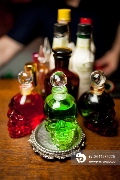 bottle skull. bottles on the bar, with colored alcohol. human crystal head skull bottle of vodka