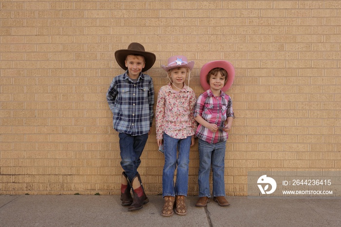 Three children dressed up as cowboys