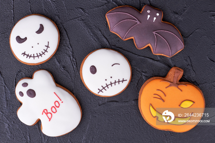 Assorted Halloween cookies on black slate. Homemade gingerbread biscuits including bat, ghost, pumpk