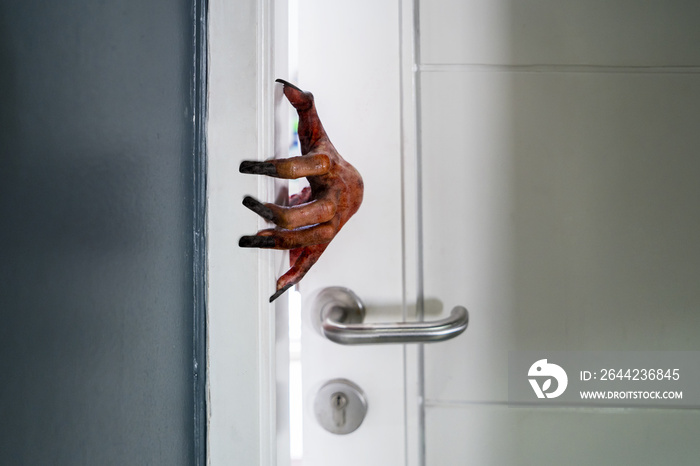 Creepy hand emerging from the open house door