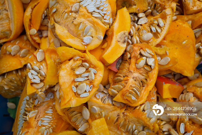 Organic waste, heap of fresh raw sliced ripe pumpkins and pumpkin seeds.