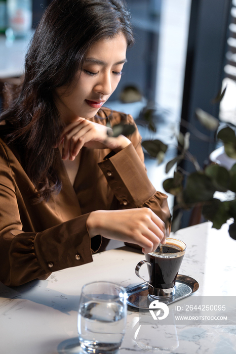 漂亮的青年女人喝咖啡