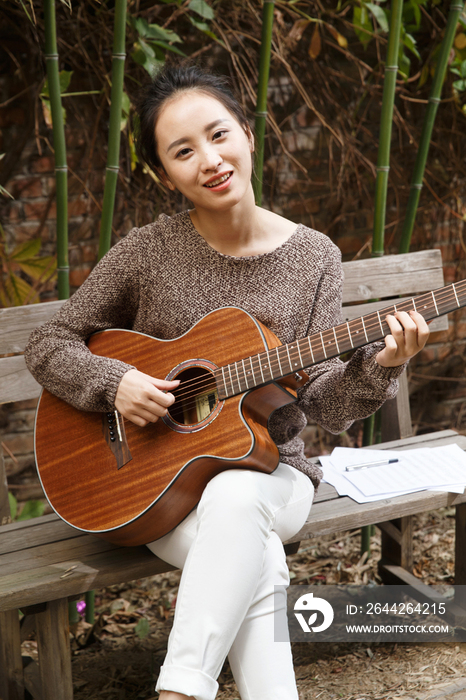 快乐的年轻女人弹吉他