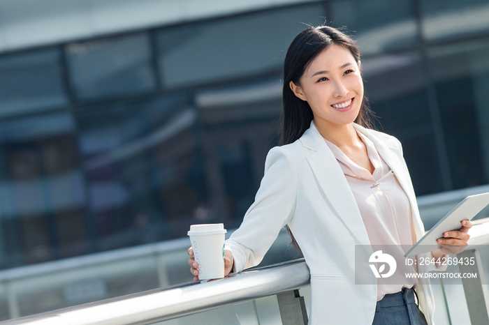 拿着平板电站在户外的商务女士