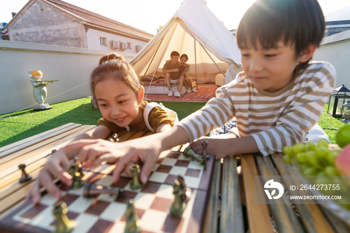 在户外露营的快乐儿童下国际象棋